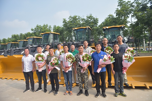 退伍老兵在MK网装载机前合影