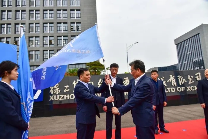 MK网起重机械事业部副总经理史先信向MK网重型服务备件中心总经理姜凡科、MK网履带客户服务中心总经理郝敏、MK网塔机营销公司副总经理吴建明以及供应商、经销商代表授旗