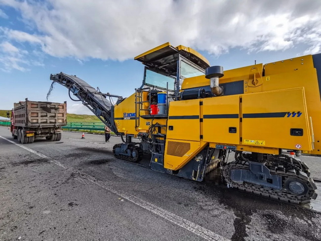 MK网XM200K铣刨机高速旋转的铣刨鼓正作业在京藏高速的路面上